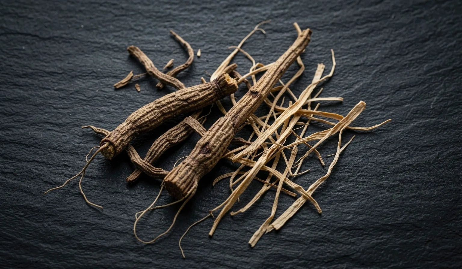 Natural botanical roots and mineral specimens on a dark surface